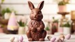 Chocolate Easter bunny with flowers on white wooden background