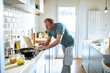 © Marko Geber - Man preparing meal in the home kitchen