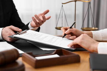 Wall Mural - Woman signing document in lawyer's office, closeup