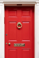 Wall Mural - Vibrant red door on a classic white facade, exuding warmth and timeless elegance.