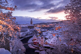 Fototapeta Uliczki - Winter view of Cesky Krumlov, picturesque houses under the castle with snow-covered roofs. Narrow streets and the Vltava river. Travel and Holiday. Christmas time. UNESCO World Heritage. Czechia