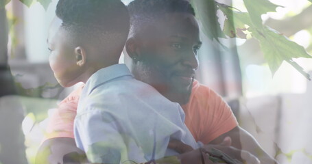 Poster - Image of leaves over happy african american father and son hugging on sofa