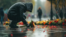 A Person Laying Flowers On A Rainy Day