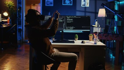 Self employed engineer using technologically advanced VR glasses in home office to do coding. Freelancing IT specialist wearing cutting edge virtual reality headset to visualize lines of code