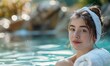 Portrait of young beautiful woman relaxing in swimming pool at spa resort