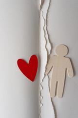 Poster - wooden figure silhouette and red heart also made of wood on book with pages torn out