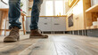 A DIY enthusiast proudly admiring their handiwork standing on newly installed vinyl plank flooring in their kitchen.