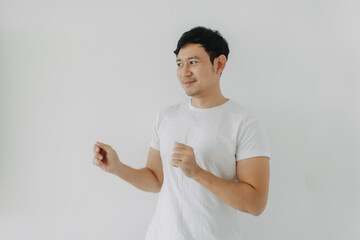 Wall Mural - Happy asian bearded man rising his fist, happy fun dancing posing, looking at empty space and standing isolated over white background wall. 