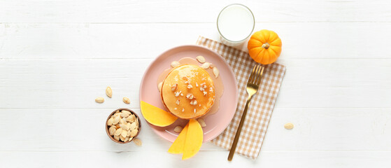 Composition with tasty pumpkin pancakes on white wooden background, top view