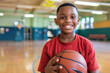 © Kien - Portrait happy boy holding basketball in a school gymnasium