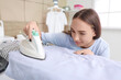 © Pixel-Shot - Pretty young woman ironing clothes in laundry room