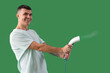 Happy young man with steamer on green background