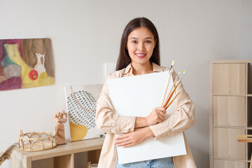 Poster - Female Asian artist with paint brushes and canvas at home