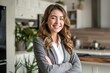 © Christiankhs - portrait of smiling businesswoman standing with crossed arms in modern kitchen