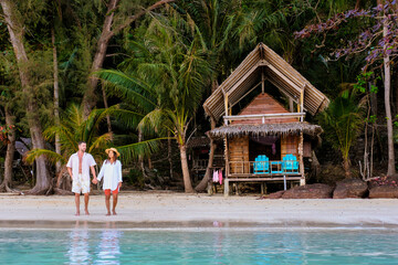 Wall Mural - wooden bamboo hut bungalow on the beach. a young couple of men and women on a tropical Island in Thailand relaxing by the ocean at sunset, Koh Wai Island, tropical holiday