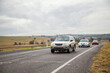 © Austockphoto - Three cars driving along country road on overcast day
