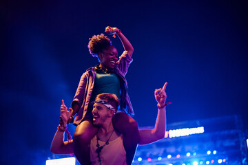 Wall Mural - Cheerful multiracial couple having fun on summer music concert at night.