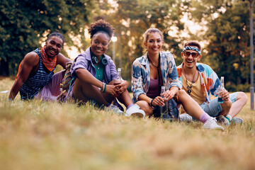 Wall Mural - Multiracial group of festival goers in park during summer looking at camera.