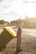 © Austockphoto - Young boy doing job taking bin across the road