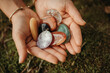 © Cavan - Woman hands holding healing gem stones on green moss