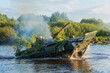 An infantry fighting vehicle swims across a river during an exercise in the summer