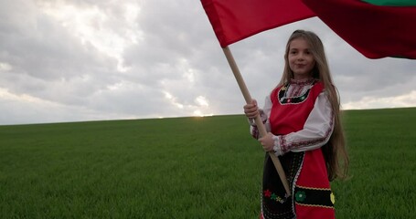 Wall Mural - Bulgarian happy girl in ethnic folklore costume proudly waving bulgarian flag against sunset sky over field, 3th March Liberation day of Bulgaria