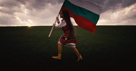 Wall Mural - Bulgarian beautiful girl in ethnic folklore costume running on green field and proudly waving the bulgarian flag on dramatic sunset, freedom, independence, liberation Bulgaria