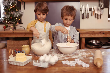 Wall Mural - Kids, baking and playing in home with flour, love and bonding with ingredients for dessert cake. Boys, mixing or bowl for christmas cookies on counter, eggs or learning of pastry recipe by cutter