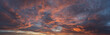 Ultrawide panorama dramatic sunset with vibrant clouds lit by a sun