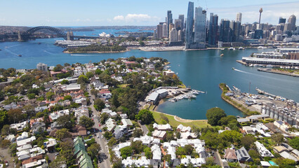 Wall Mural - Aerial drone view over Balmain in Sydney, New South Wales, Australia looking toward Balmain East showing Sydney Harbour Bridge and Sydney City in the background on a sunny day    