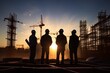 Silhouetted engineers working at sunset 