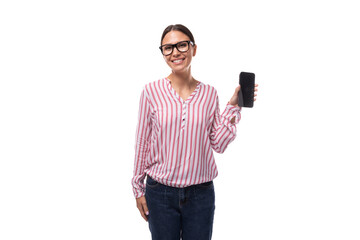 Wall Mural - young lady office employee dressed in pink white blouse and jeans shows smartphone screen with mockup