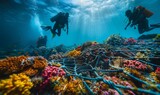 Fototapeta Do akwarium - Divers Exploring Coral Reef Entangled in Fishing Net