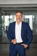 © Stock 4 You - Handsome hispanic senior business man standing at office, smiling at camera. Vertical portrait of happy European latin Indian confident mature good looking middle age leader male businessman at work