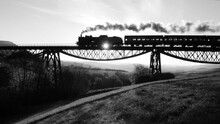 Grayscale Video Of Locomotive Crossing A Rural Bridge