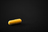 Fototapeta  - Medical pills. Color capsules medication. Black background. Health care concept. Free space for text. Medicines. Many different pills. Chemical industry.