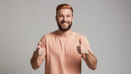 Wall Mural - A bearded man in a casual peach T-shirt gives two thumbs up, smiling confidently. Studio shot against a light grey background.