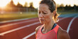 Lifestyle portrait of mature woman athlete standing on race track, exhausted and upset after losing running marathon