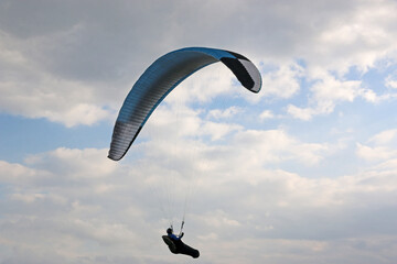 Poster - Paraglider flying in a cloudy sky	