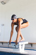 © Wavebreak Media - Caucasian female athlete swimmer poised on a starting block at a pool, with copy space