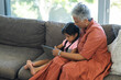 © Wavebreak Media - Grandmother and biracial granddaughter enjoy a tablet together on the sofa at home