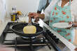 © Wavebreak Media - Biracial couple cooking together in a home kitchen, including preparing pancakes