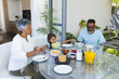 © Wavebreak Media - Biracial grandparents and granddaughter enjoy breakfast at home