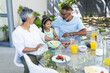 © Wavebreak Media - Biracial grandparents enjoy breakfast together with their granddaughter at home