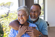 © Wavebreak Media - Senior biracial couple shares a joyful embrace at home