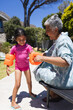 © Wavebreak Media - Biracial granddaughter prepares for a swim, assisted by a grandmother