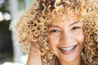 © Wavebreak Media - Young biracial woman smiles brightly, showcasing braces