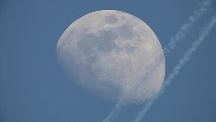 Wall Mural - video of the moon in which you can see the craters. a plane passes in front of the moon at that prec