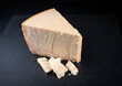 Traditionelles Parmesan Käse Stück als Nahaufnahme auf einem schwarzen Design Board mit Textfreiraum