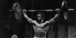 Olympic weightlifting concept with man holding heavy weights over his head - black and white photo 